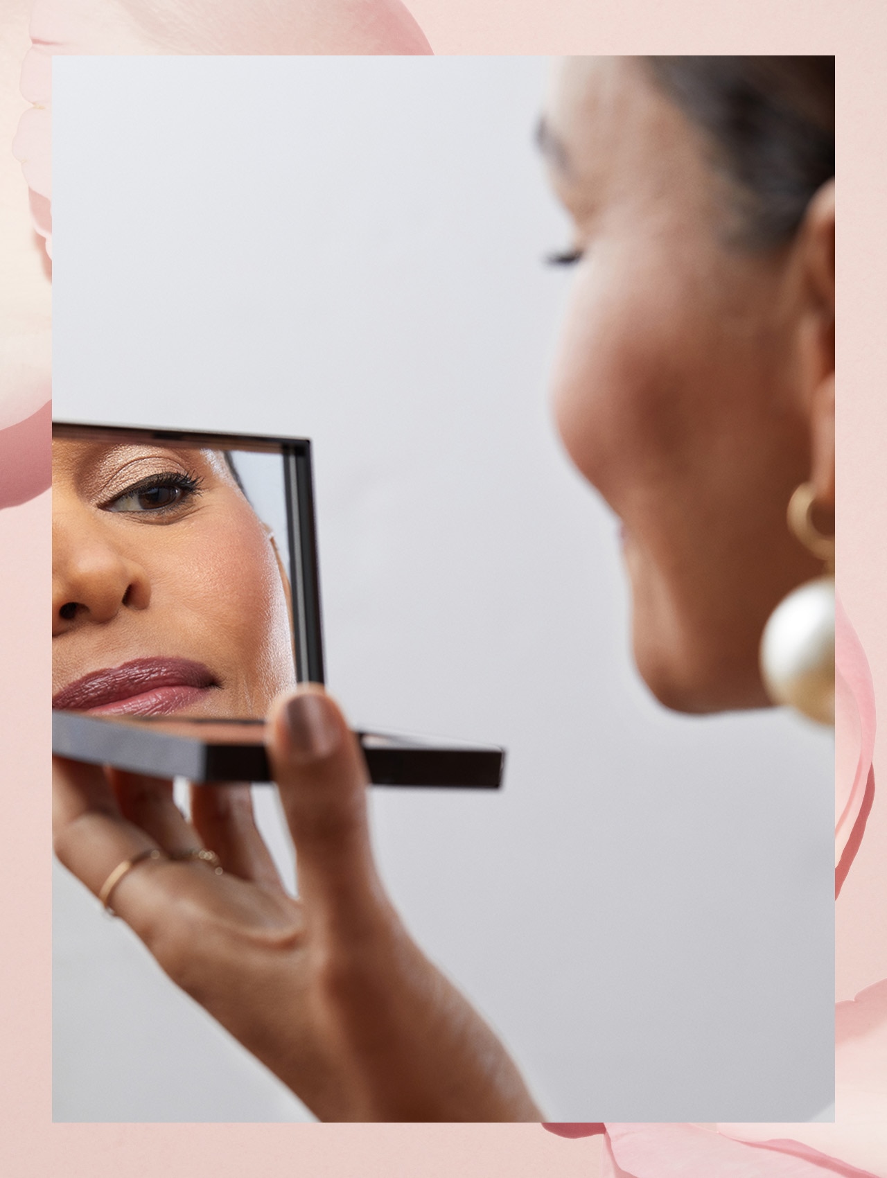 Imagine containing step 5 model applying lipstick, smiling while looking into compact Bobbi Brown mirror