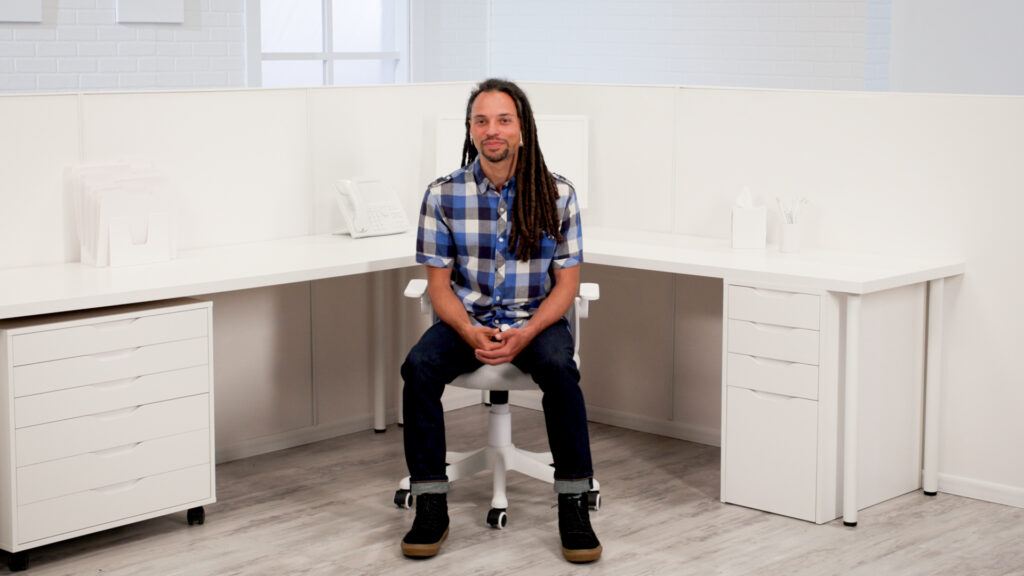 Wellbeats instructor Chance Y. sits in a desk chair to lead Brain Recharge class.