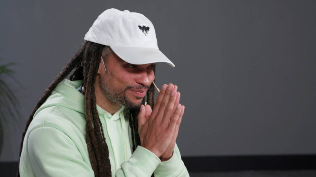 Wellbeats instructor Chance Y. bows forward with his hands in prayer position to lead a breathing check-in