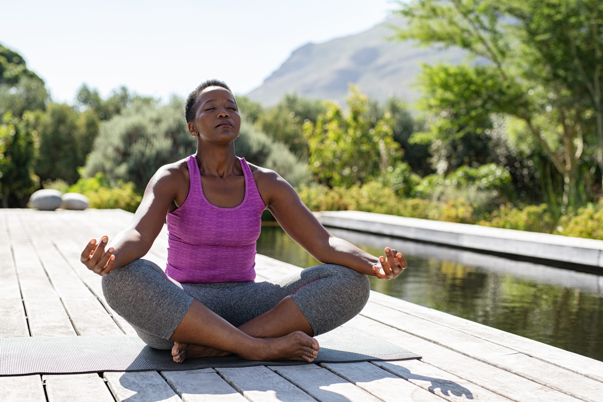 A woman practices yoga outside in a park